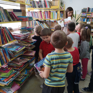 Wizyta grupy starszej w bibliotece publicznej- dzieci oglądają książki