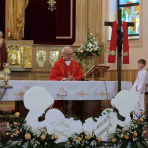 Ksiądz przy ołtarzu sprawuje uroczystą Mszę Świętą.