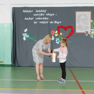 Uczennica przedszkola wyłania poprzez losowanie karty odpowiedzi quizu zwycięzców.