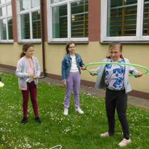 Grupa uczniów wykonujących zadania przy jednej ze stacji gry terenowej. 