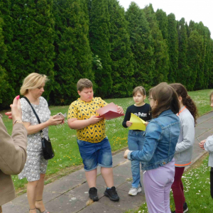 Grupa uczniów wykonujących zadania przy jednej ze stacji gry terenowej. 