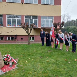 Dyrektor szkoły, ks. Proboszcz oraz  uczniowie w Poczcie sztandarowym składają hołd Poległym za Ojczyznę.