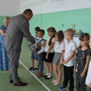 Dyrektor szkoły p. Tomasz Dudzic i wychowawczyni p. Anna Flis wręczają nagrody sześciolatkom.