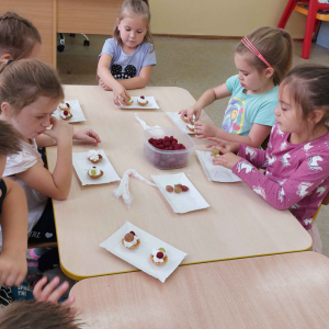 Dziewczynki dekorują babeczki owocami