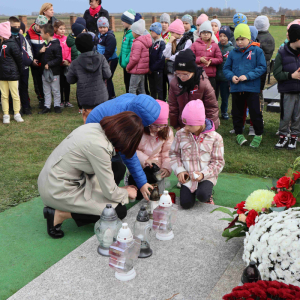 Zapalenie zniczy przez uczniów  wraz z Panią Bogumiłą Małek