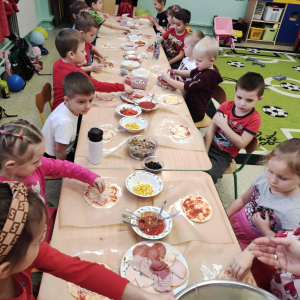 Dzień pizzy w przedszkolu - Dzieci nakładają ulubione składniki na pizzę