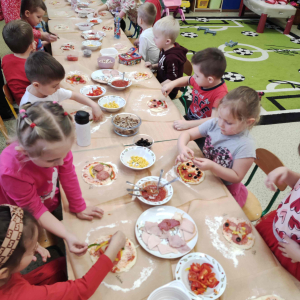 Dzień pizzy w przedszkolu - Dzieci nakładają ulubione składniki na pizzę