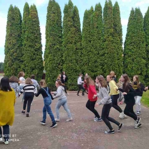 Uczniowie wraz z opiekunami samorządu uczniowskiego tańczą na dziedzińcu szkoły