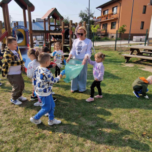 Dzieci przedszkolne sprzątają plac zabaw