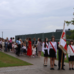 Poczet sztandarowy wraz z dyrekcją, nauczycielami i uczniami w drodze do kościoła