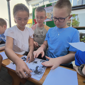 Narodowe Czytanie 2025 - uczeniowie klasy  IV układają puzzle.
