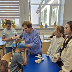 Pełne skupienie i zaangażowanie uczestników podczas nauki prawidłowego bandażowania.