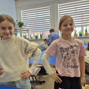 Uczennice z dumą prezentują efekty swojej pracy – bandażowanie zakończone sukcesem.