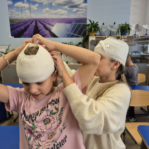 Współpraca i koncentracja – uczennice doskonalą technikę zakładania opatrunku głowy.