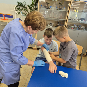 Pełne skupienie i zaangażowanie uczestników podczas nauki prawidłowego bandażowania.