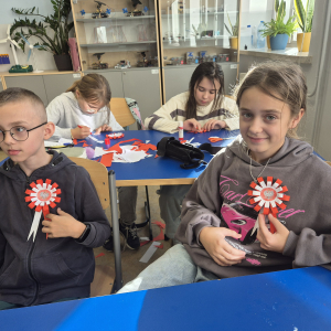 Uczniowie z dumą prezentują własnoręcznie wykonane kotyliony.