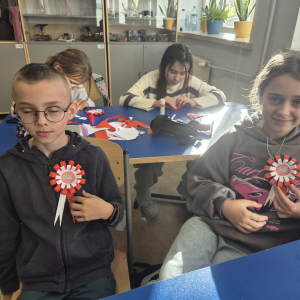 Uczniowie z dumą prezentują własnoręcznie wykonane kotyliony.