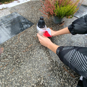 Uczniowie składają znicze ozdobione biało-czerwonym sercem na grobach poległych za Ojczyznę.