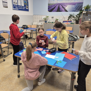 Dzieci pracują nad elementami papierowych ozdób