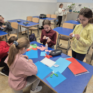 Uczniowie przygotowują materiały do wykonania świątecznych kartek.
