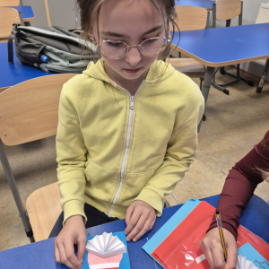 2.	Uczennica prezentuje etap tworzenia świątecznej kartki.