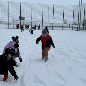 Zabawy starszaków na śniegu.