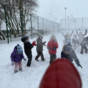 Zabawy starszaków na śniegu.