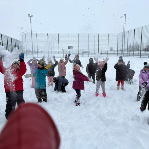 Zabawy starszaków na śniegu.