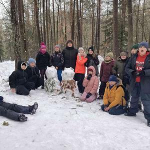 Uczniowie klasy 5 wraz z wychowawcą przy ulepionym przez siebie bałwanie